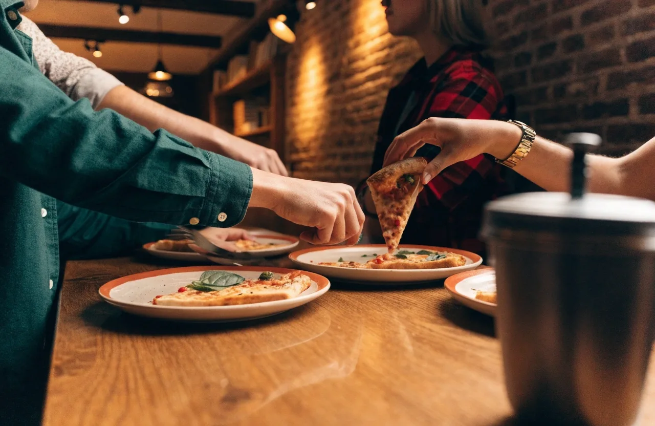 Friends sharing thin-crust pizzas at a restaurant table